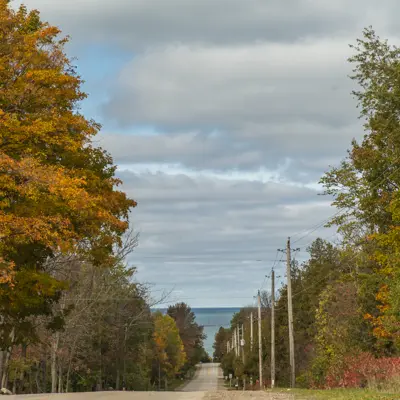 A road winds downhill towards Lake Huron.